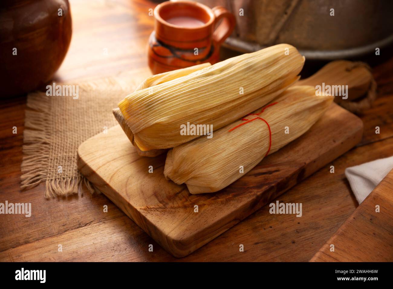 Tamales. Piatto prehispanico tipico del Messico e di alcuni paesi dell'America Latina. Pasta di mais avvolta in foglie di mais. I tamales vengono cotti al vapore. Foto Stock