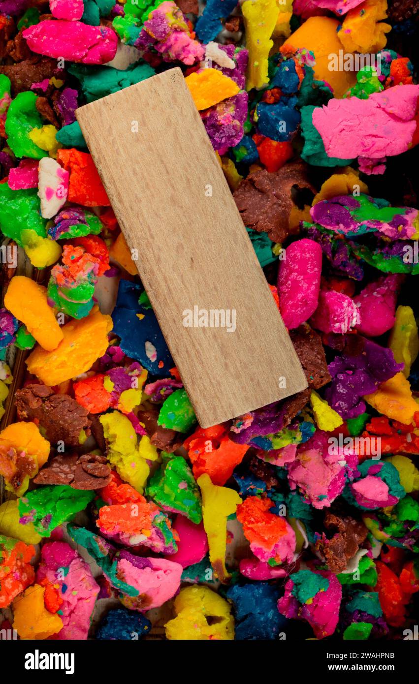 Un pezzo di legno sul gioco colorato impasto in piccoli pezzi Foto Stock