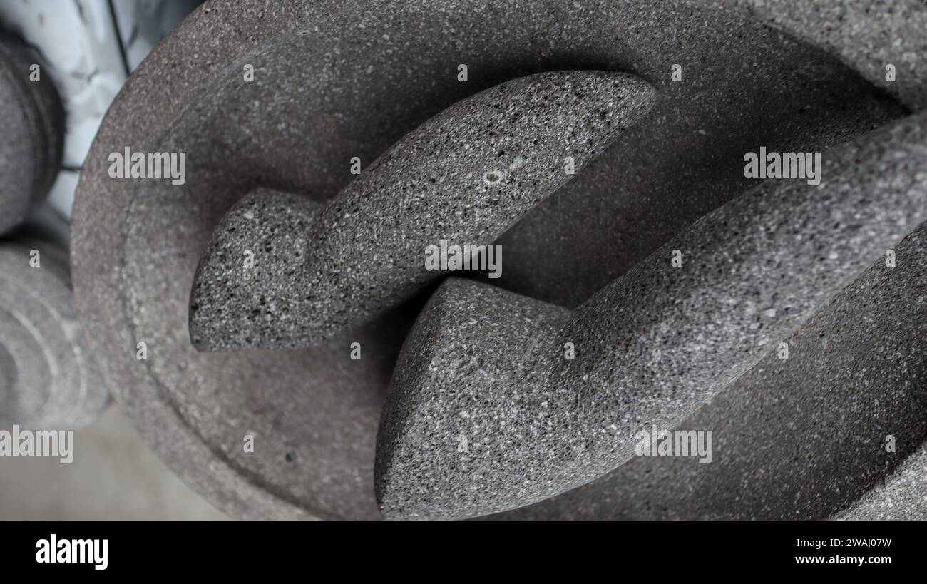 Utensili da cucina tradizionali indonesiani chiamati cobek e ulekan. mortaio di pietra e pestello, utilizzati per tritare le erbe e preparare il sapore naturale o la salsa al peperoncino Foto Stock