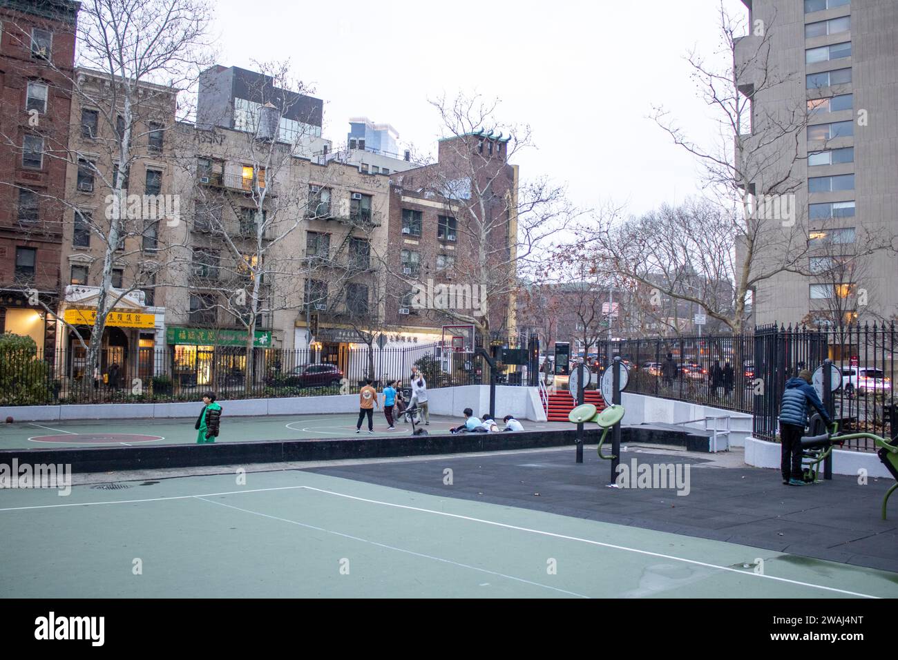 Un gruppo di bambini gioca una partita competitiva di basket all'aperto a New York, Stati Uniti Foto Stock