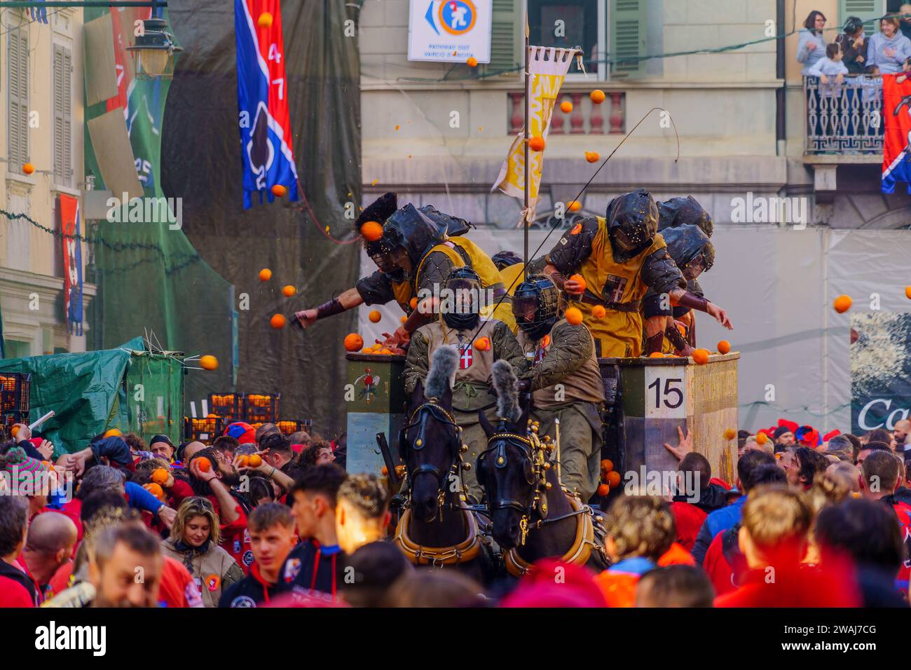 Ivrea, Italia - 19 febbraio 2023: Gruppi in medicazioni tradizionali, e folla con cappelli rossi, partecipano alla Battaglia degli arance, parte della storia Foto Stock