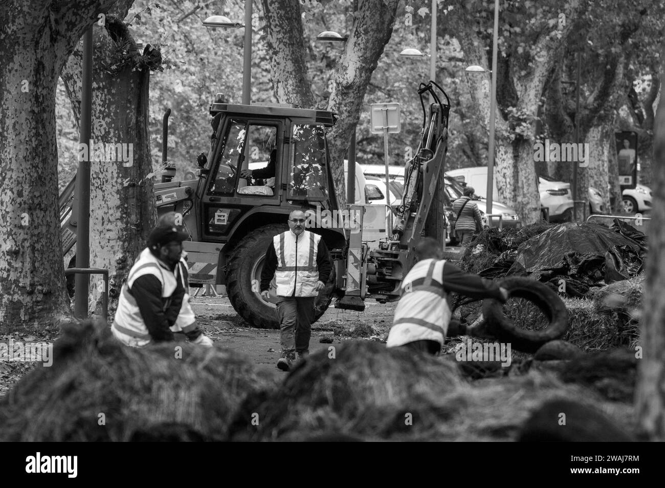 I lavoratori che puliscono pneumatici e letame in dumping dopo la protesta degli agricoltori, Quai Eugène Cavaignac, Cahors, dipartimento Lot, Francia Foto Stock