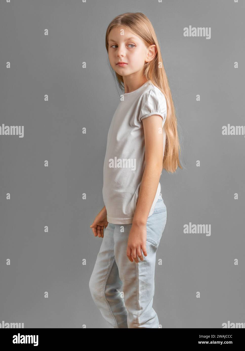 Ritratto di una bambina carina con lunghi capelli chiari in t-shirt bianca Foto Stock