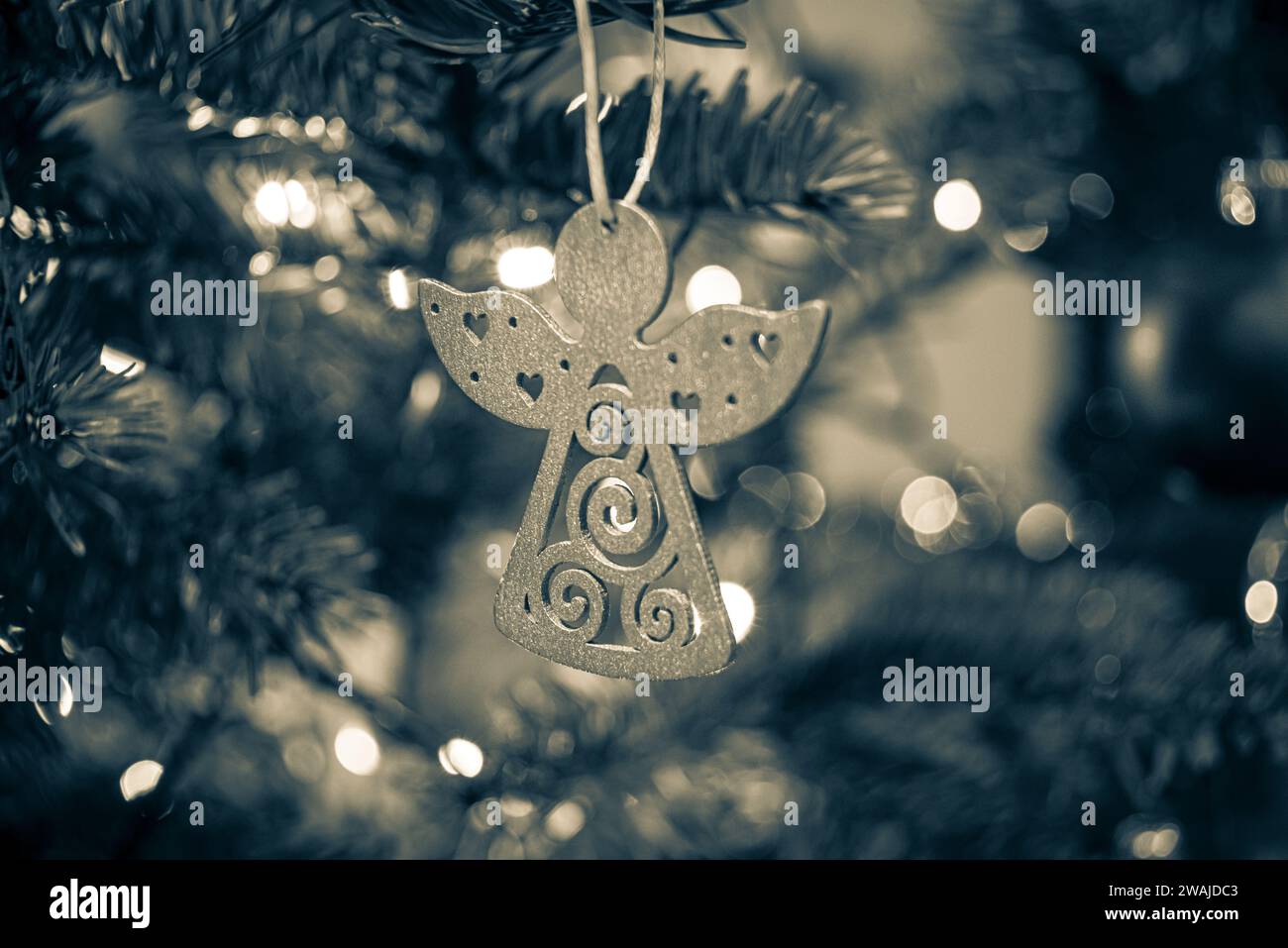 Un ornamento angelico su un tradizionale albero di Natale, che aggiunge un tocco di festa alla stagione natalizia Foto Stock