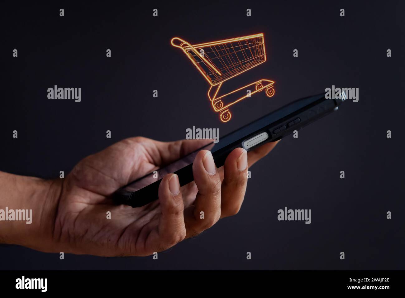 Icona del carrello per la spesa con la mano che regge lo smartphone. Shopping online, concetto di business. Foto Stock