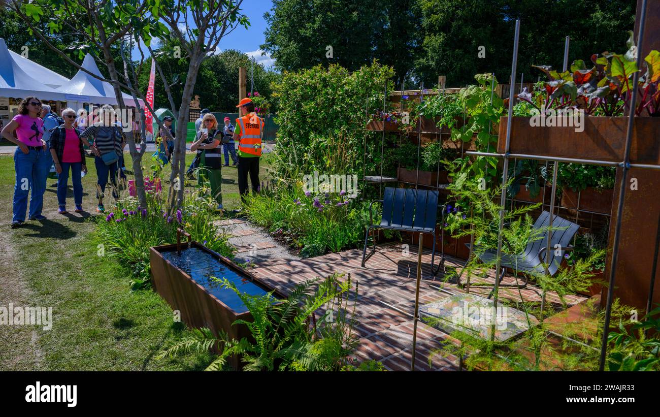 Partecipazione al concorso Brickyard Garden (visitatori e persone che vedono il vincitore della medaglia d'oro, piccolo patio) - RHS Tatton Park Flower Show 2023, Cheshire, Inghilterra, Regno Unito. Foto Stock