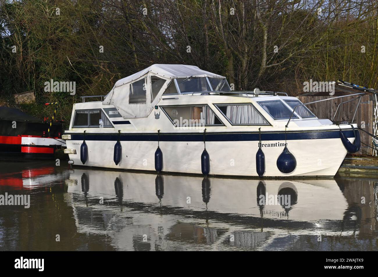 Una barca da diporto che si riflette nell'acqua di alto livello sul canale di Oxford vicino ad Aynho. Foto Stock