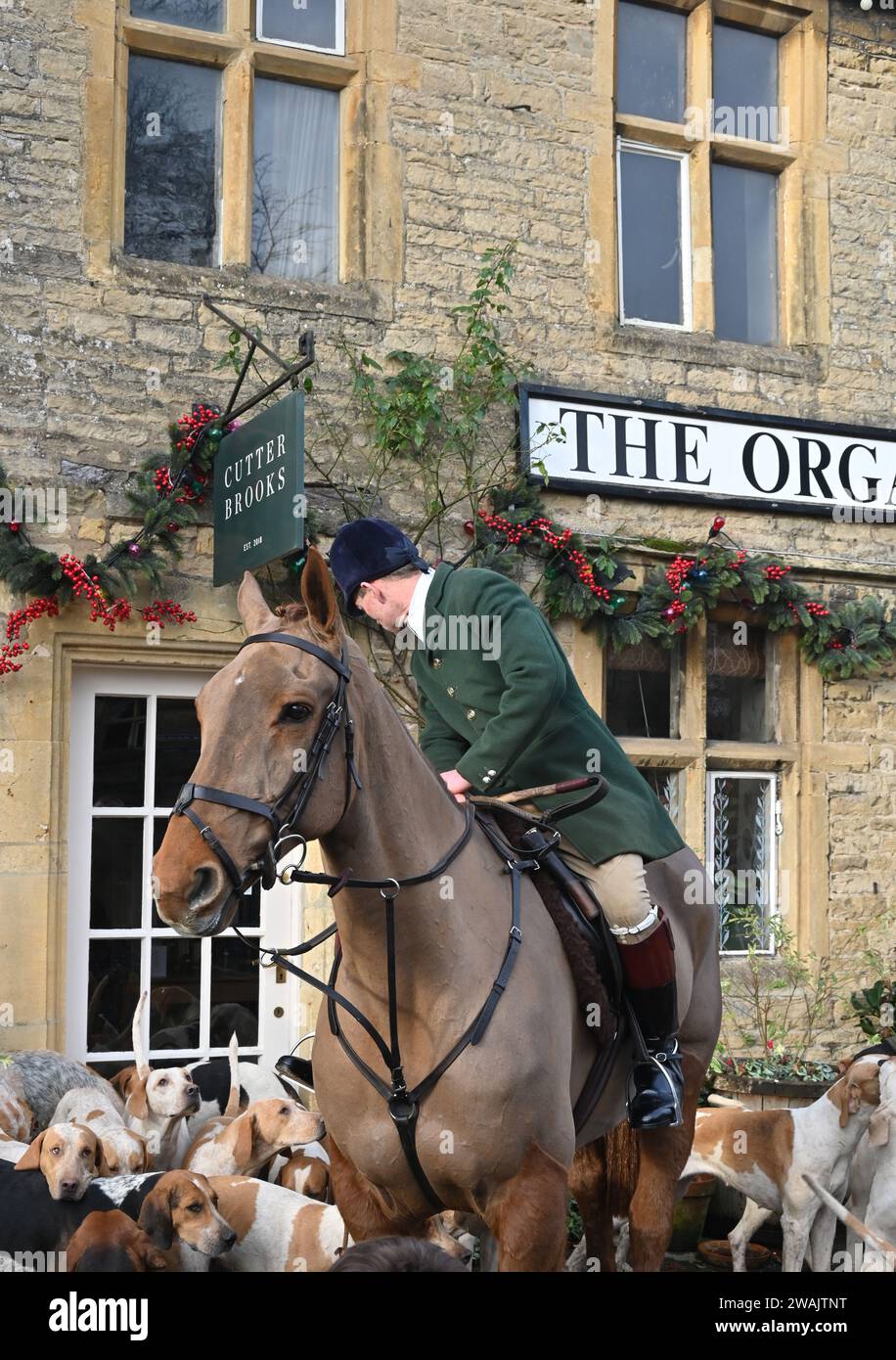 La caccia all'Heythrop organizza tradizionalmente un incontro il giorno di Capodanno nella città Cotswold di Stow on the Wold, Gloucestershire. Huntsman Chris Woodward. Foto Stock