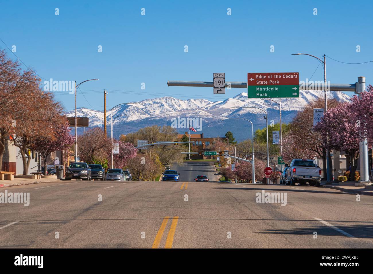 La piccola e tranquilla cittadina di Blanding, nello Utah meridionale, strada principale con vista dalla sua strada principale verso montagne innevate, cielo blu profondo e primavera. Foto Stock