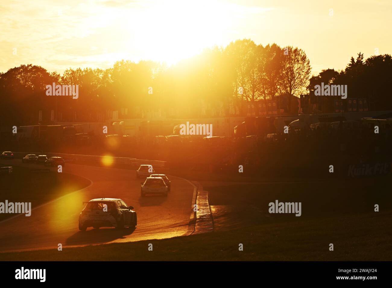 Auto da corsa di Rory Butcher che corre al tramonto a Brands Hatch, Kent Foto Stock