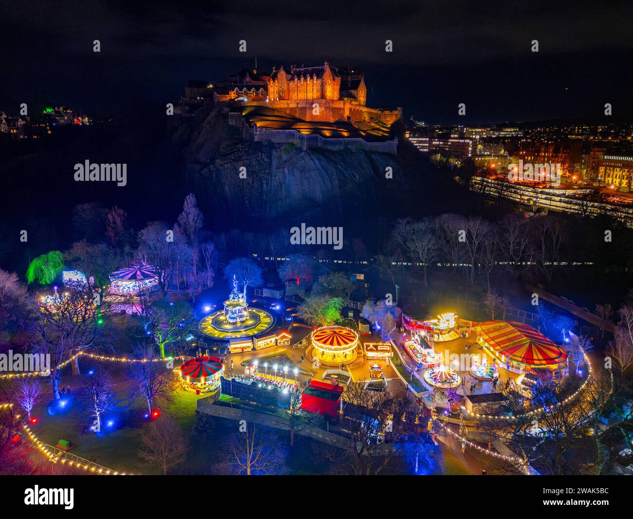 Vista aerea notturna dal drone del Castello di Edimburgo e del mercato di Natale nei West Princes Street Gardens di Edimburgo, Scozia, Regno Unito Foto Stock