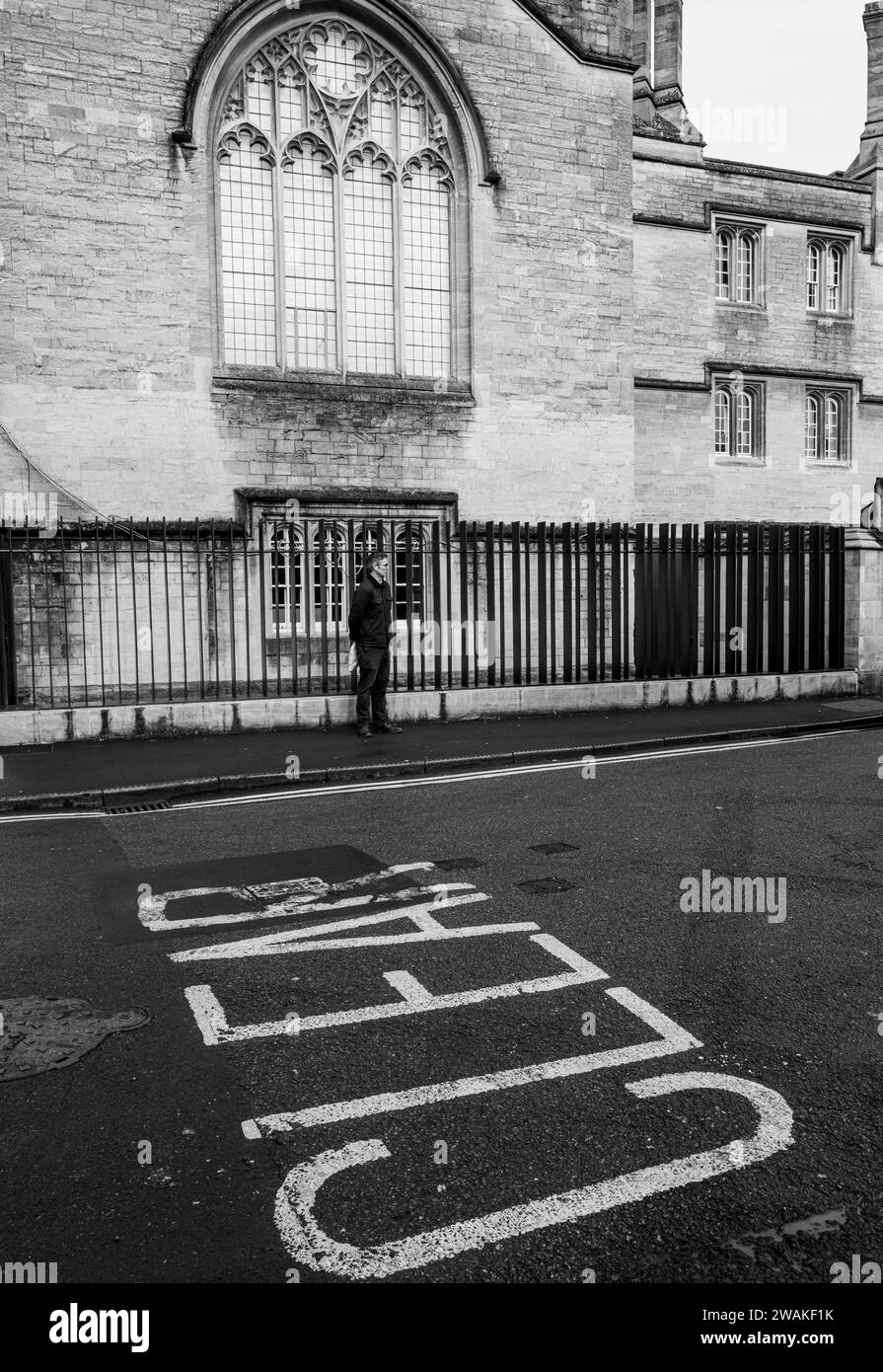 Un uomo in piedi contro le ringhiere a Market Street, Oxford, Inghilterra. Di fronte al mercato coperto Foto Stock