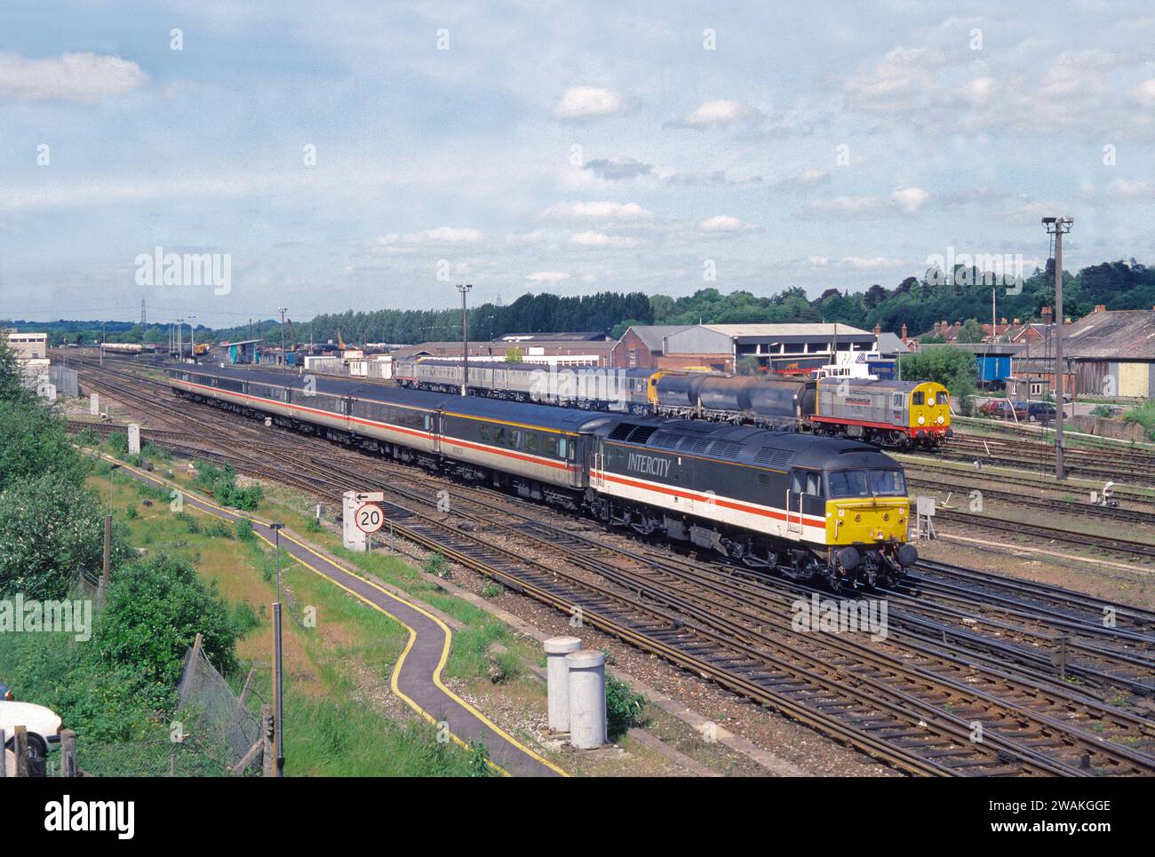 Una locomotiva diesel di classe 47 numero 47822 funzionante un servizio Intercity passa accanto al cantiere di Eastleigh, che ha Hunslet-Barclay classe 20 numeri 20901 e 20904 e il treno per la spargimento della chipman-Nomix in attesa del prossimo lavoro. Eastleigh, 5 giugno 1994. Foto Stock Una locomotiva diesel di classe 47 numero 47822 funzionante un servizio Intercity passa accanto al cantiere di Eastleigh, che ha Hunslet-Barclay classe 20 numeri 20901 e 20904 e il treno per la spargimento della chipman-Nomix in attesa del prossimo lavoro. Eastleigh, 5 giugno 1994. Foto Stock