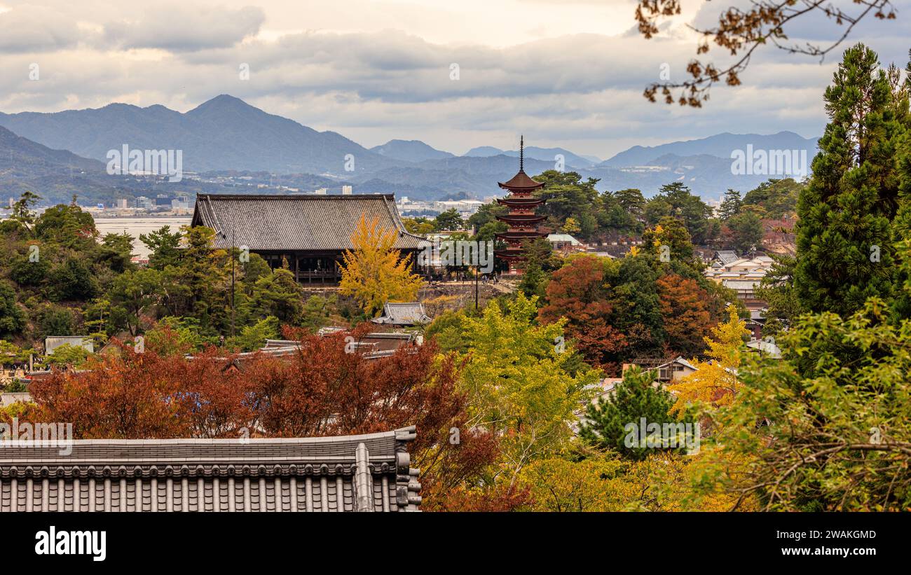 vista dalla collina dell'isola di miyajima del santuario di itsukushima e della pagoda a cinque piani circondata dal colorato fogliame autunnale e dalle montagne di hiroshima ba Foto Stock