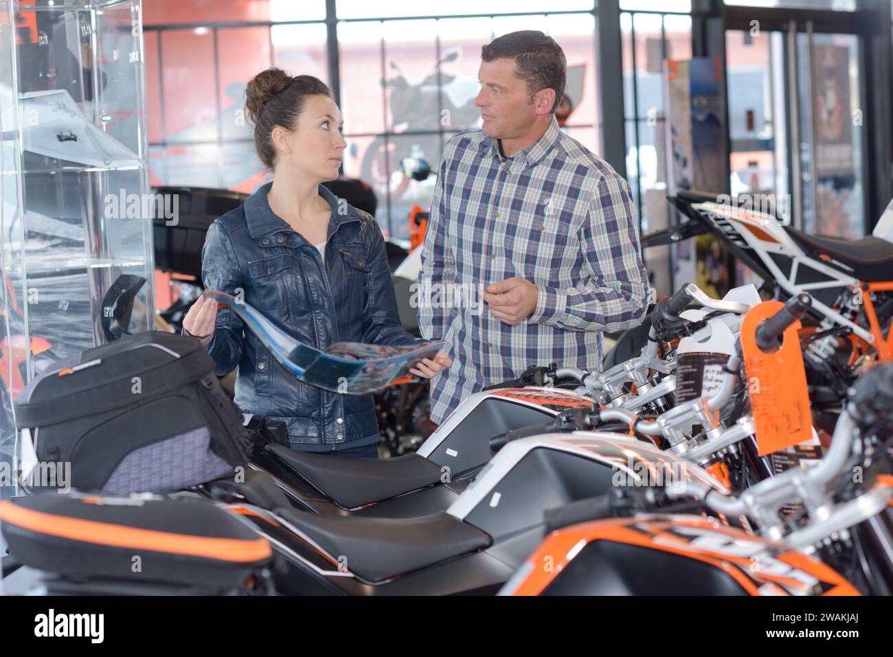 coppia nello showroom motociclistico con brochure Foto Stock