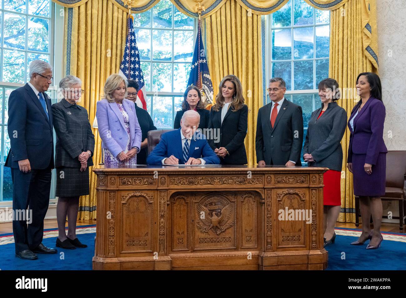 Washington, Stati Uniti d'America. 13 novembre 2023. Il presidente degli Stati Uniti Joe Biden, centro, raggiunto dalla First Lady Jill Biden, sinistra, firma il memorandum presidenziale sulla ricerca sulla salute delle donne, durante una cerimonia presso l'Ufficio ovale, 13 novembre 2023 a Washington, D.C. credito: Erin Scott/White House Photo/Alamy Live News Foto Stock