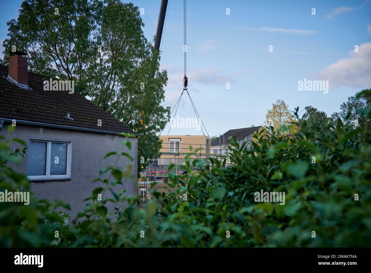 In Essen Kettwig baut der Bauverein Kettwig a Ickten neu. Die Bauweise besteht aus Fertigbauteilen. Ein Fertigbauteil wird mit einem Kran eingehobe Foto Stock