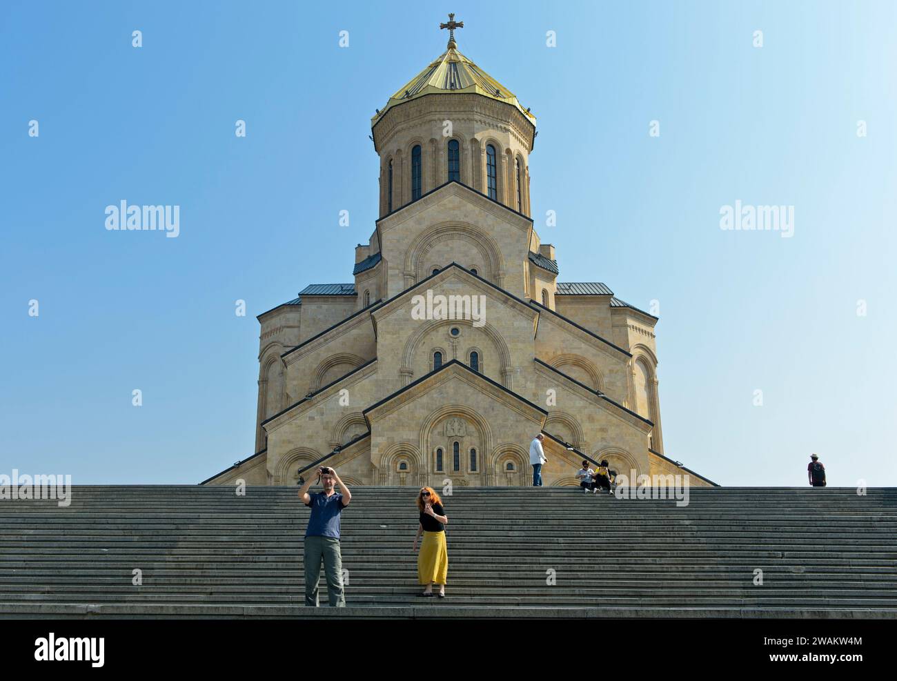 I turisti scattano foto di selfie sulle scale di fronte alla cattedrale di Sameba, alla chiesa della Santissima Trinità, alla facciata ovest, al quartiere Avlabari, a Tbilisi, Georgia Foto Stock