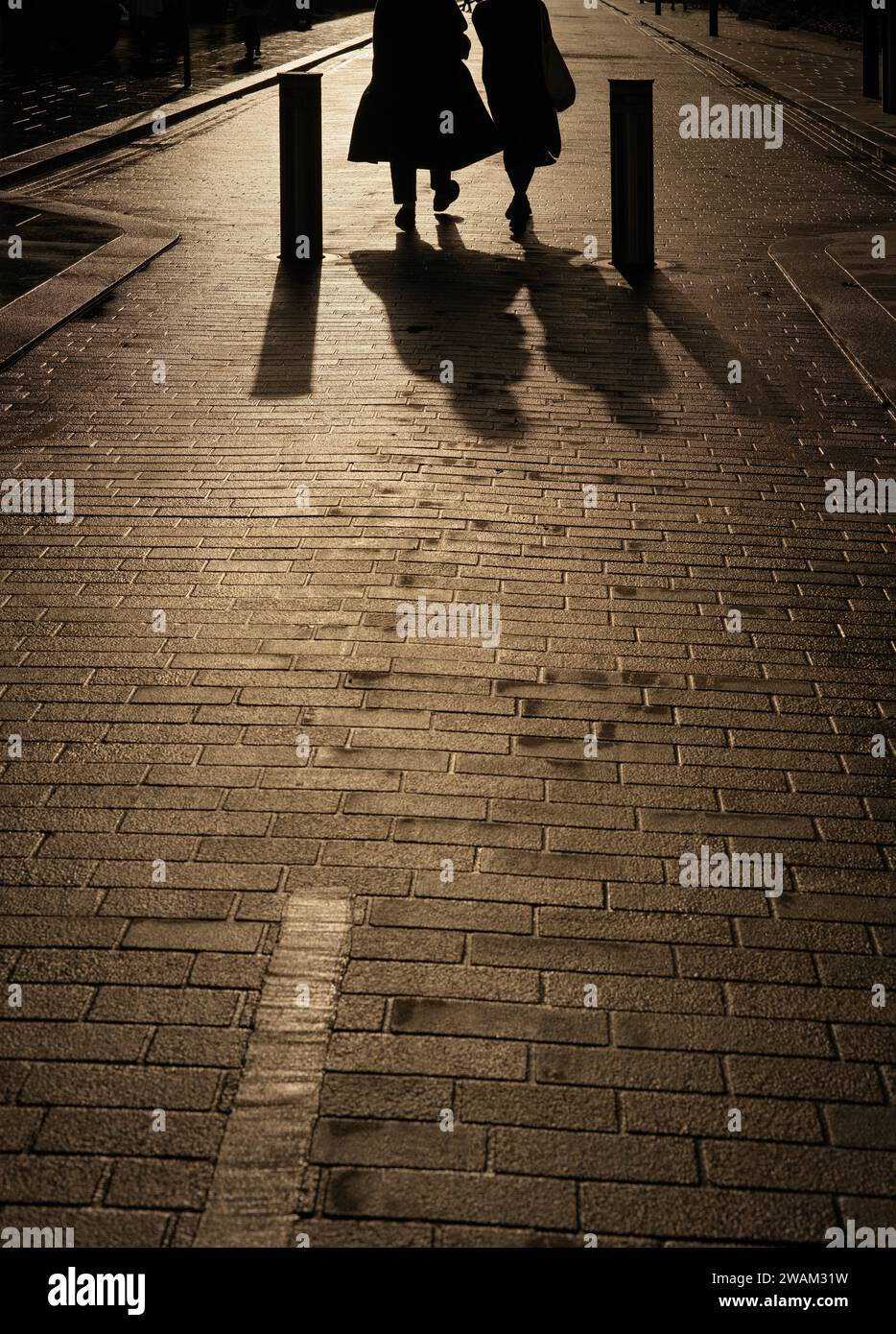 due persone camminano lungo la strada pedonale della città Foto Stock