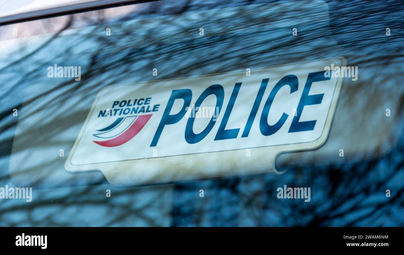 Primo piano della piastra dell'aletta parasole di un veicolo della polizia non contrassegnato con la parola "POLIZIA" e il logo della polizia nazionale francese Foto Stock