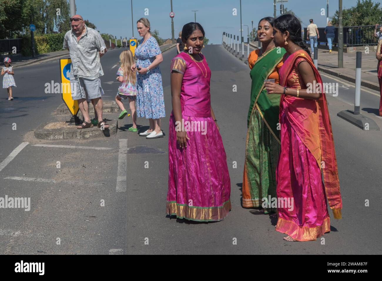 Immigrazione in Gran Bretagna, società multiculturale britannica, gruppo di giovani donne indù Tamil partecipano a un tradizionale festival annuale indù nella periferia di Wimbledon. Anche i residenti inglesi locali guardano la processione. Londra Inghilterra 2022 2000 HOMER SYKES Foto Stock