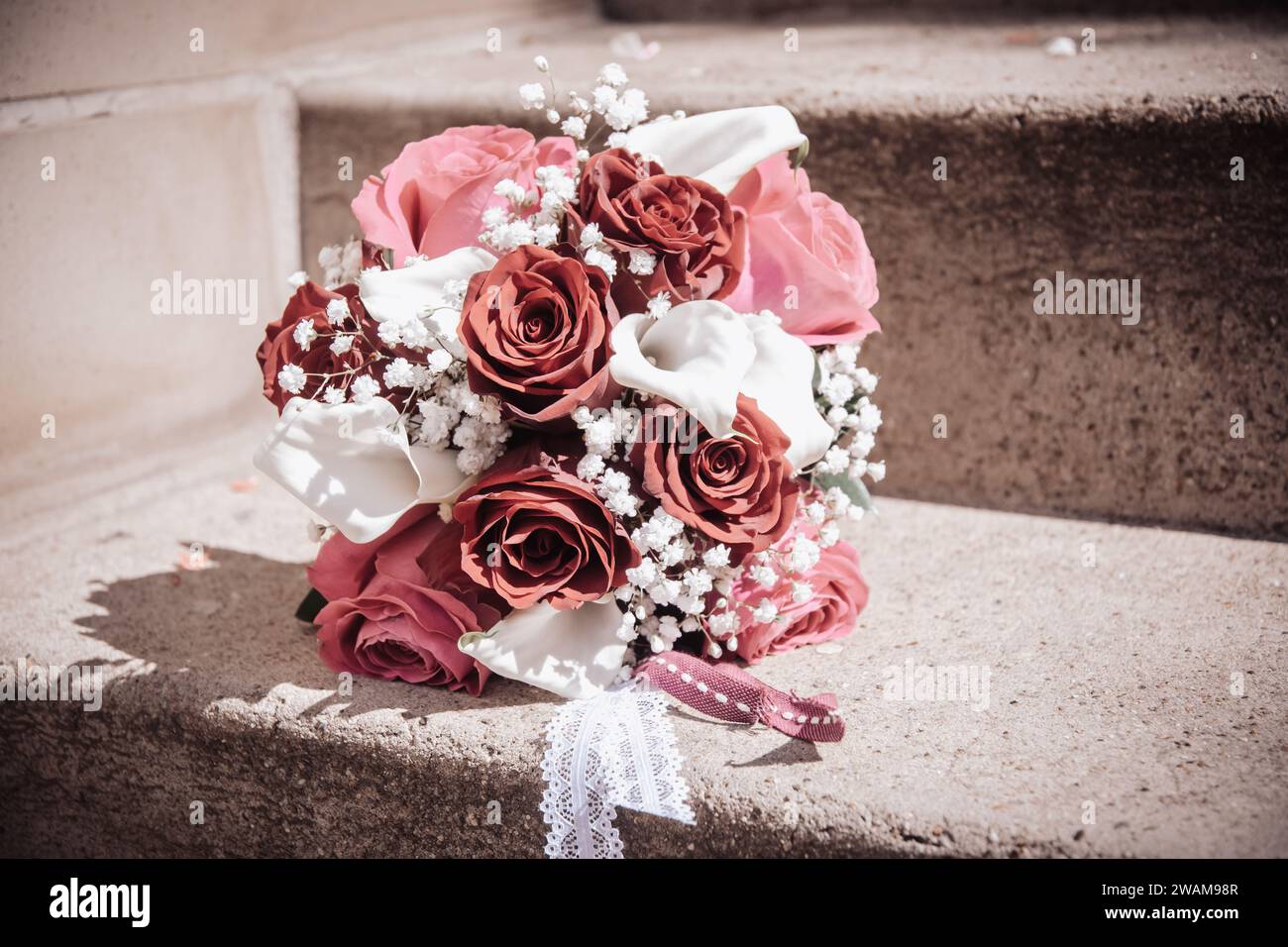 Bouquet nuziale con rose rosse, rosa e bianche e callas bianche, spazio copia Foto Stock