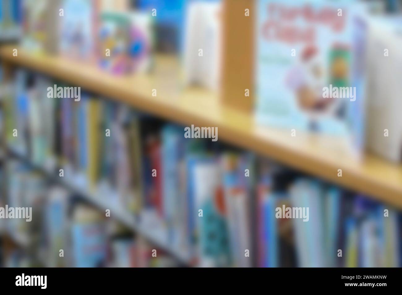 Libreria sfocata astratta con libri illustrati per bambini. Foto Stock