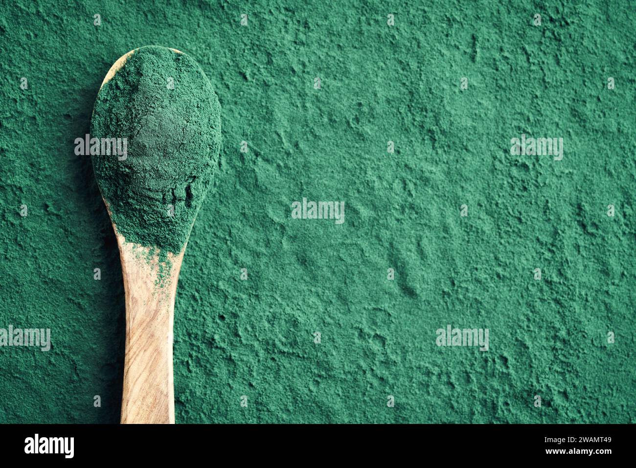 Polvere di spirulina verde su un cucchiaio di legno con spazio copia Foto Stock