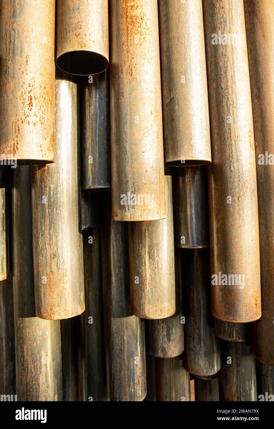 Ferro arrugginito, tubi metallici simmetrici sotto il sole, con ombra chiara Foto Stock