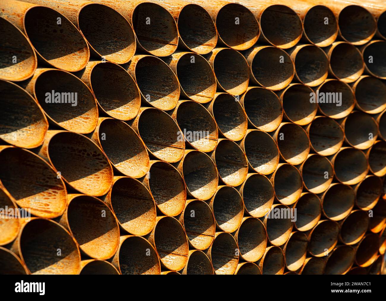 Ferro arrugginito, tubi metallici simmetrici sotto il sole, con ombra chiara Foto Stock