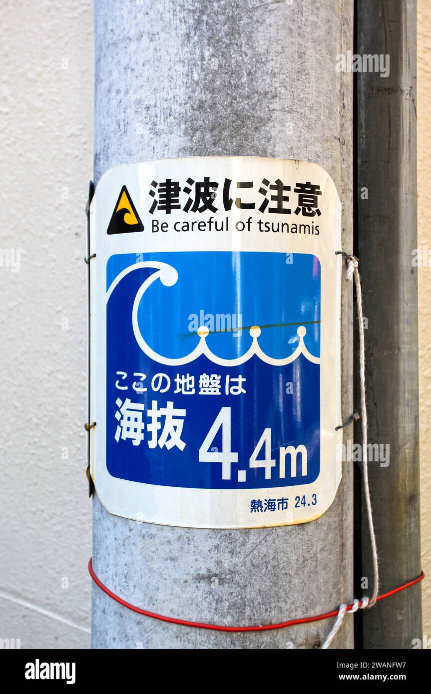 Segnale di avvertimento tsunami e segnale di elevazione su Street Post ad Atam, Giappone. Foto Stock