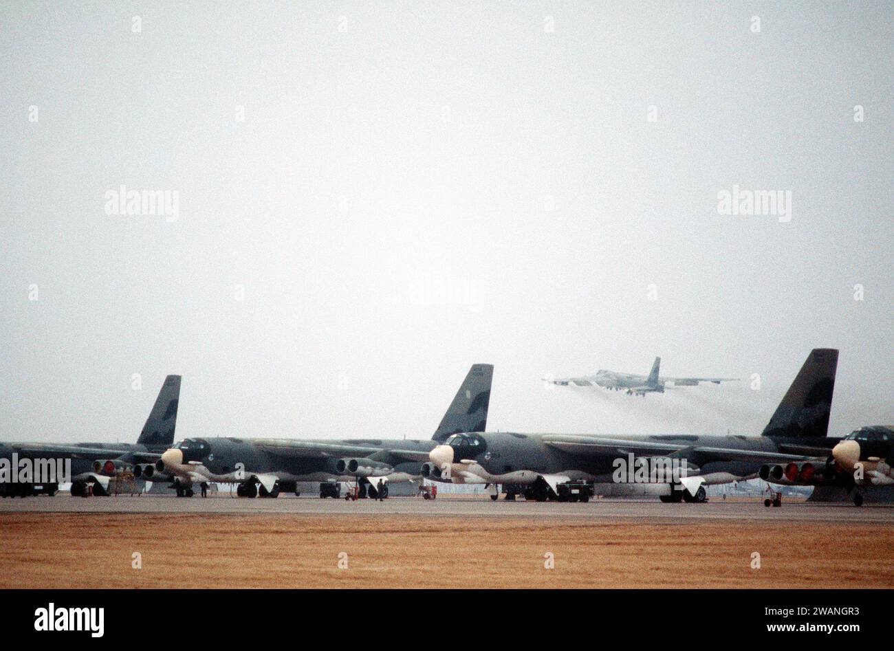 Una vista frontale sinistra degli aerei B-52 Stratofortress in preparazione per una missione di allerta quando un altro B-52 (sullo sfondo) decolla nel 1981 Foto Stock