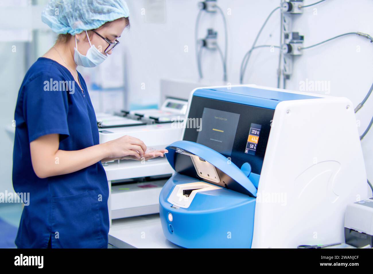 Il medico in labaratorio apre il coltivatore IVF. Processo di inseminazione dell'uovo da parte dell'embriologo nel laboratorio della fecondazione in vitro. Foto Stock