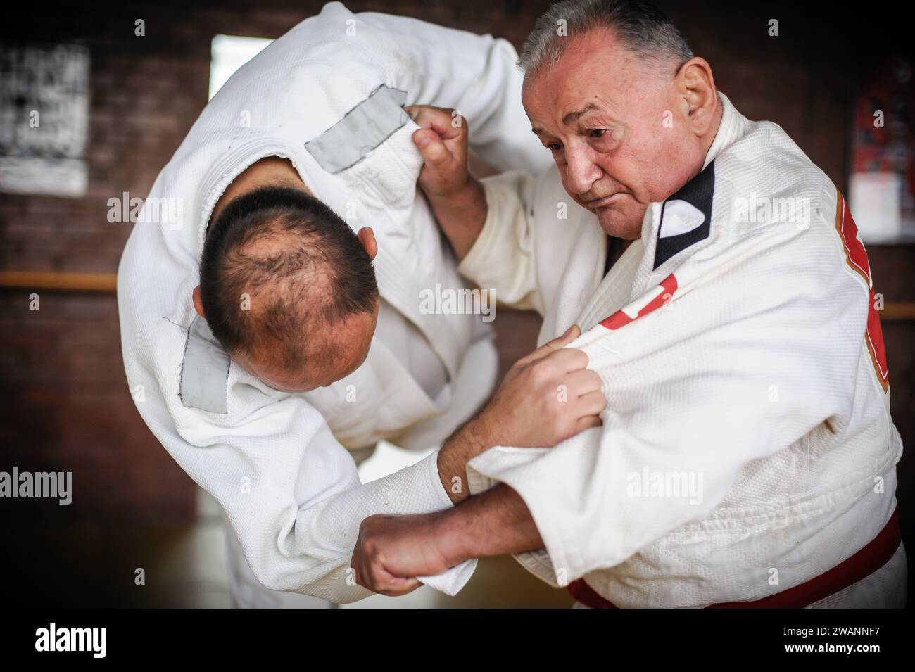 Il ritratto ravvicinato del maestro di judo sensei in gi kimono tradizionale dimostra la tecnica del judo Foto Stock