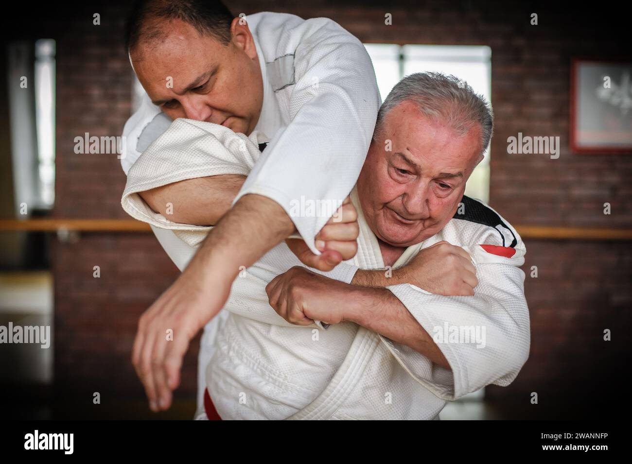 Il ritratto ravvicinato del maestro di judo sensei in gi kimono tradizionale dimostra la tecnica del judo Foto Stock