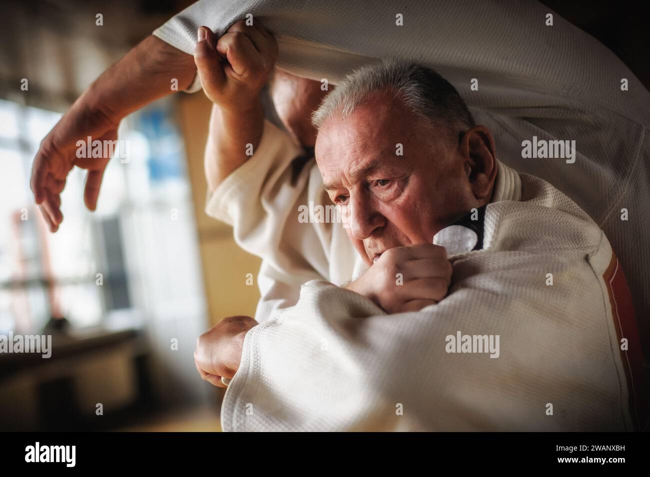 Il ritratto ravvicinato del maestro di judo sensei in gi kimono tradizionale dimostra la tecnica del judo Foto Stock