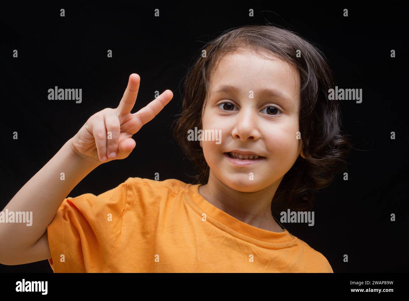 Sorridente ragazzo con faccia felice e vittoria gesto di pace Foto Stock