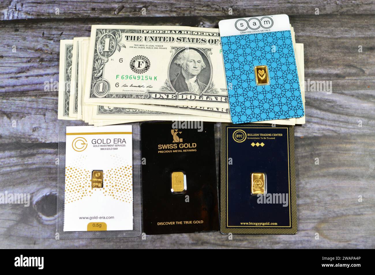 Cairo, Egitto, 2 gennaio 2024: Banconote in denaro di dollari americani USD, Stati Uniti d'America Money, SAM, BTC, oro svizzero, oro 24 Karate pure y Foto Stock