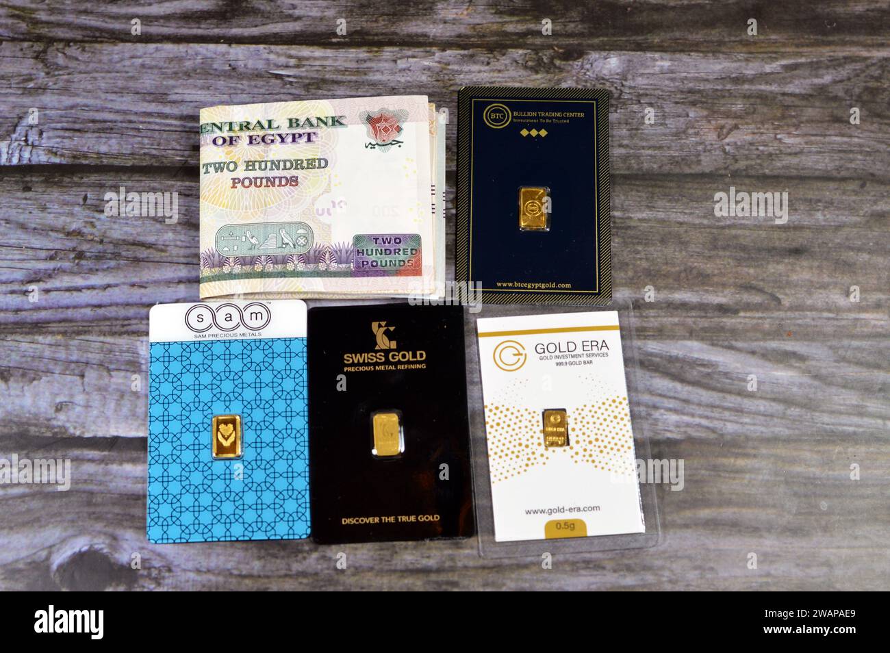 Cairo, Egitto, 2 gennaio 2024: Libbre egiziane con SAM, BTC, oro svizzero, oro 24 Karate lingotti in oro giallo puro, investimento, tasso di cambio, in Foto Stock