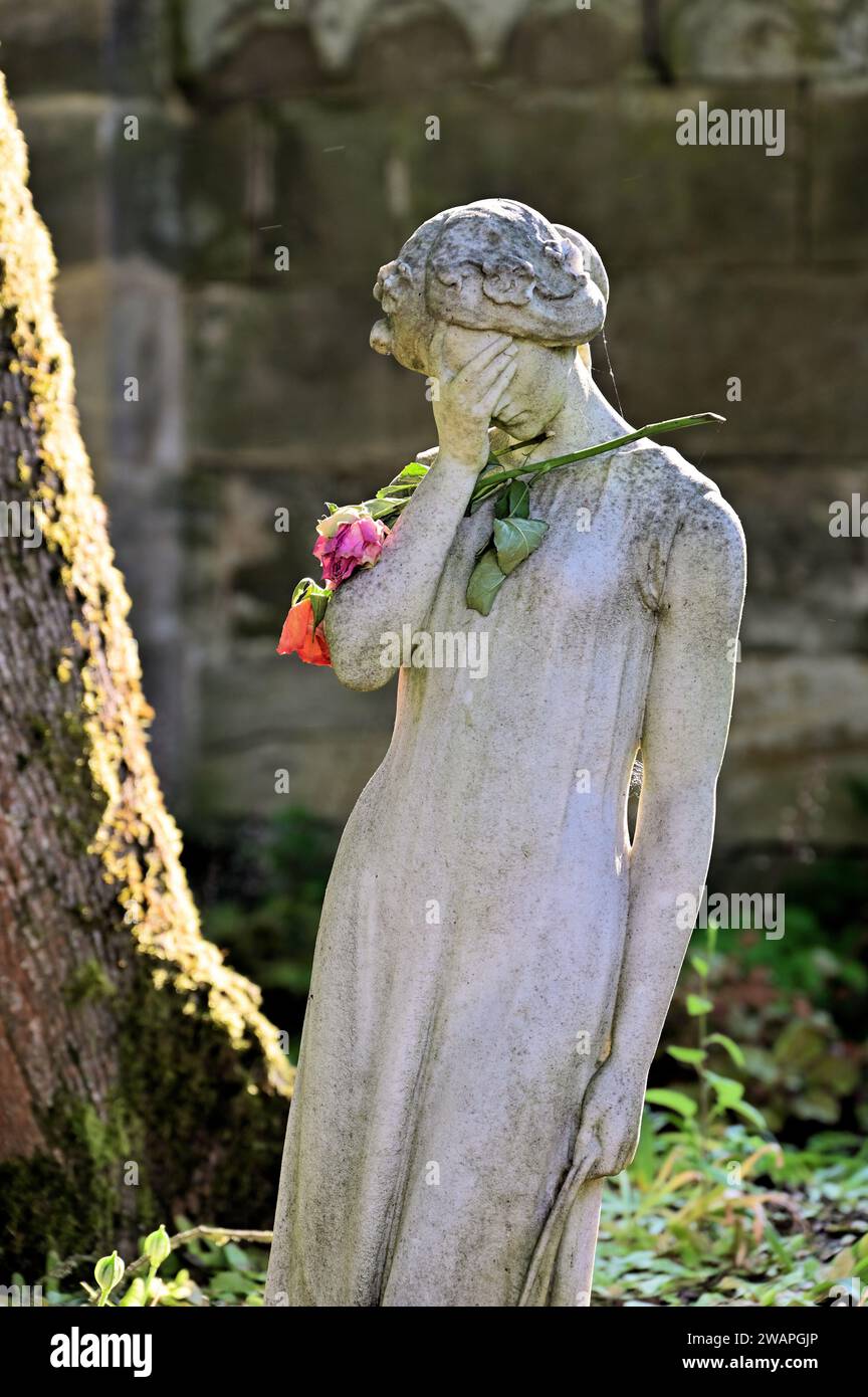 Scultura donna in lutto con una rosa Foto Stock
