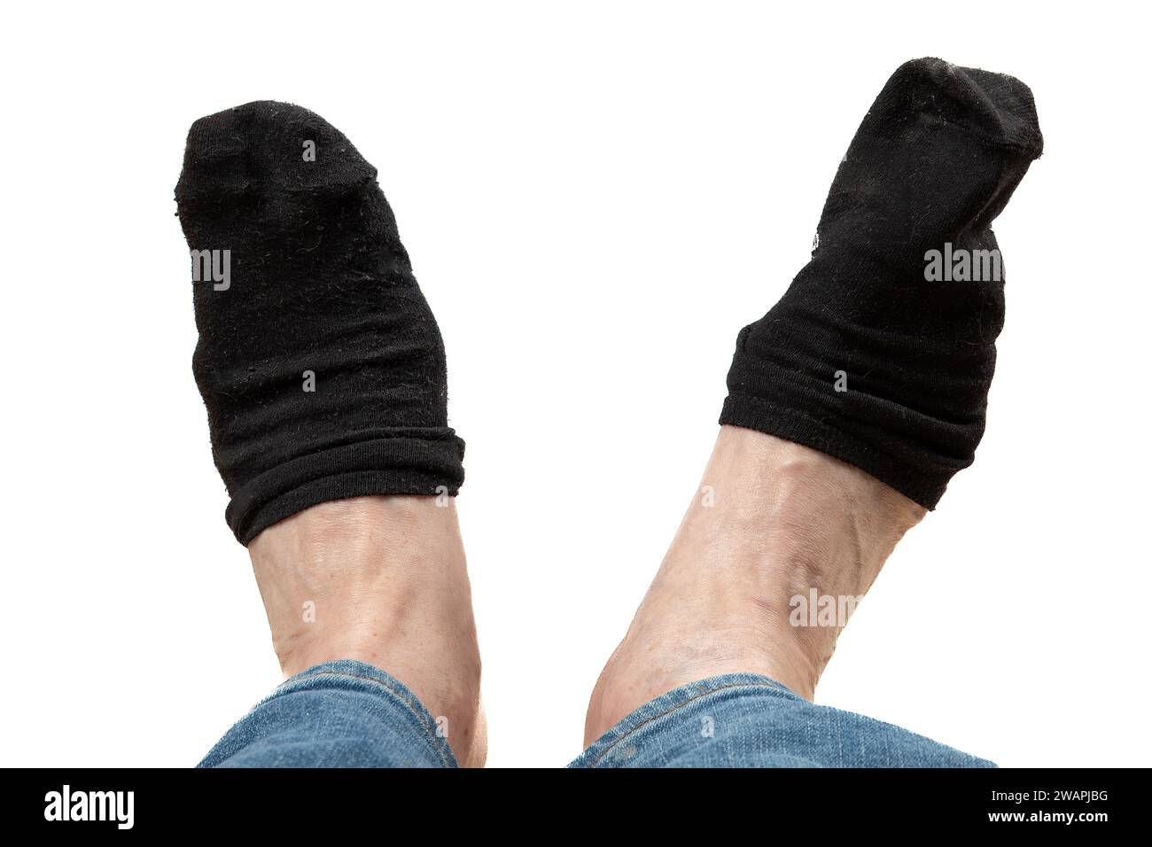 Piedi scomodi: Calzini neri sporchi, scivolanti troppo corti - sfondo bianco Foto Stock