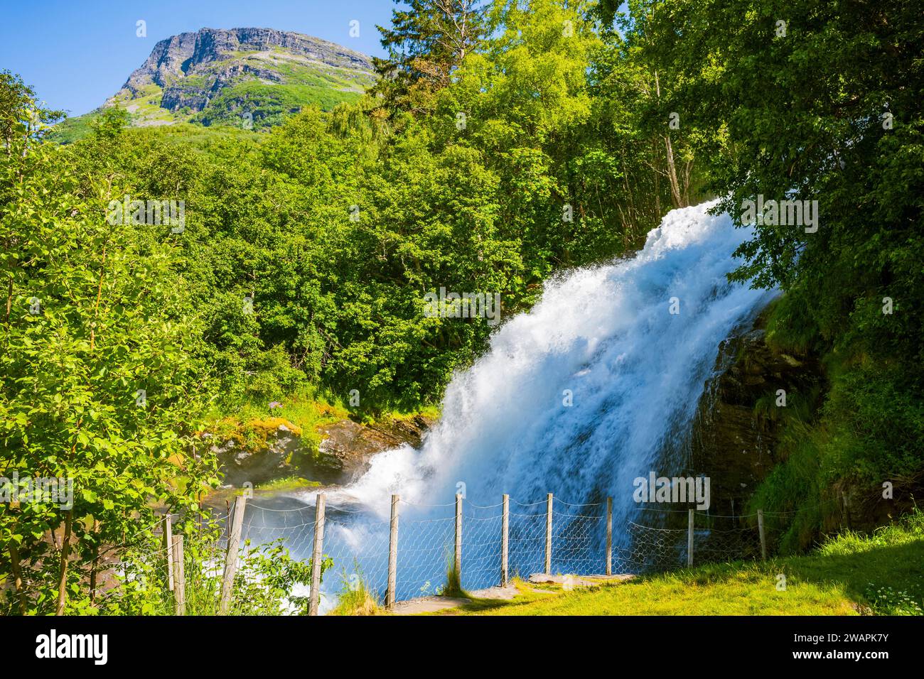 Una piccola cascata di nome Kleivafossen situata vicino a un campeggio nel piccolo villaggio e popolare località di viaggio Geiranger, Norvegia, un patrimonio mondiale dell'UNESCO Foto Stock