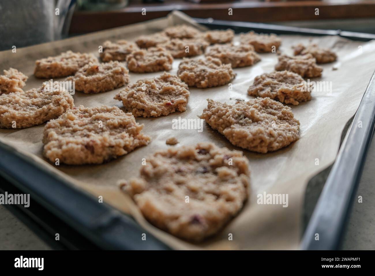 biscotti non cotti di farina di mandorle keto rivestiti su carta pergamena, su un vassoio pronto da portare in forno Foto Stock