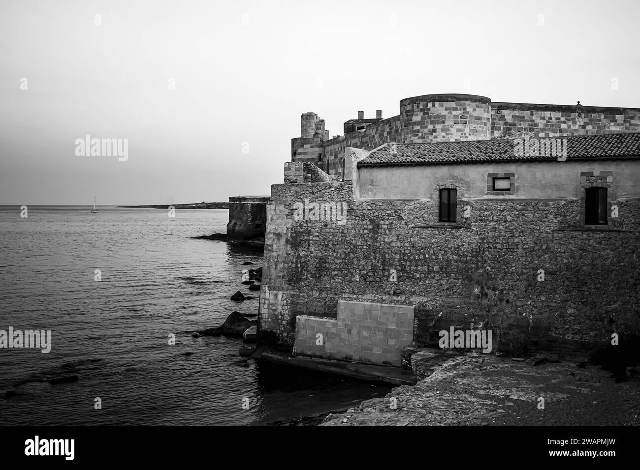 Un edificio storico tocca la splendida costa di Ortigia, perla turistica di Siracusa Foto Stock
