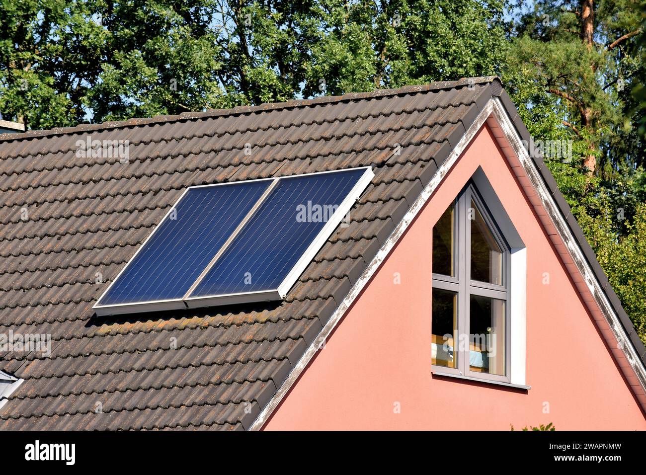 Collettori termici solari sul tetto della casa per una produzione ecologica di riscaldamento e acqua calda per uso domestico Foto Stock