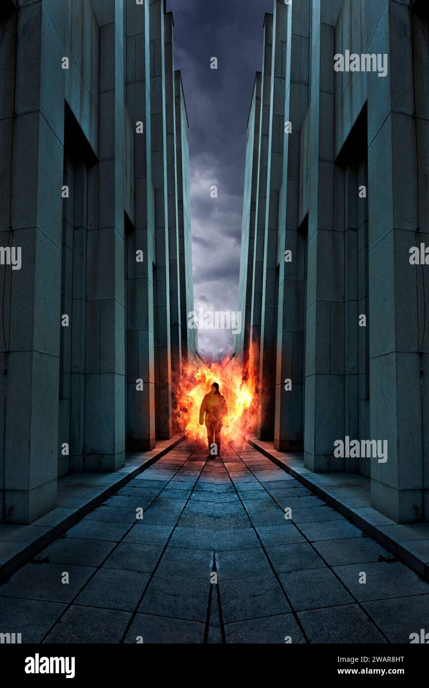 uomo che cammina tra alti edifici murati, che esce da una palla di fuoco Foto Stock