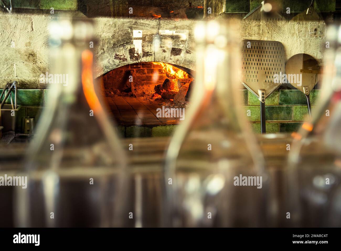 Tre bottiglie di vetro trasparente vuote disposte accanto a un forno bianco Foto Stock