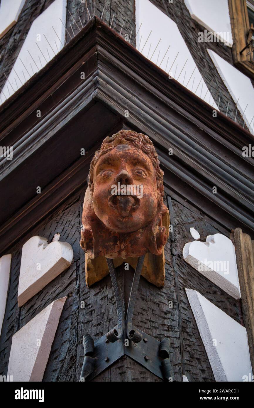 Una scultura artistica di un volto umano esposta sul lato di un edificio. Foto Stock