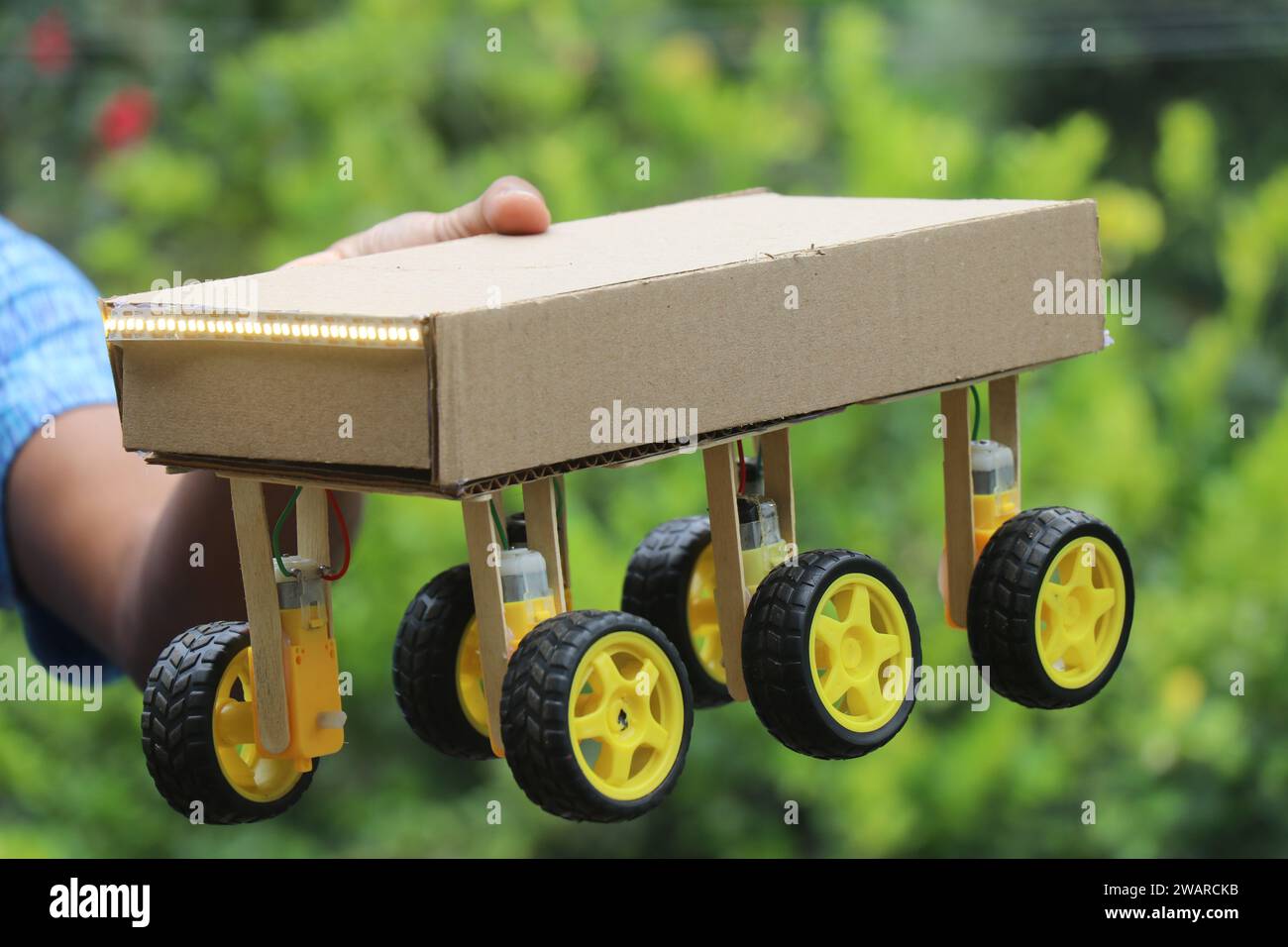 Auto robotizzata controllabile da uno smartphone e dotata di un sistema a sei ruote motrici tenuto in mano Foto Stock