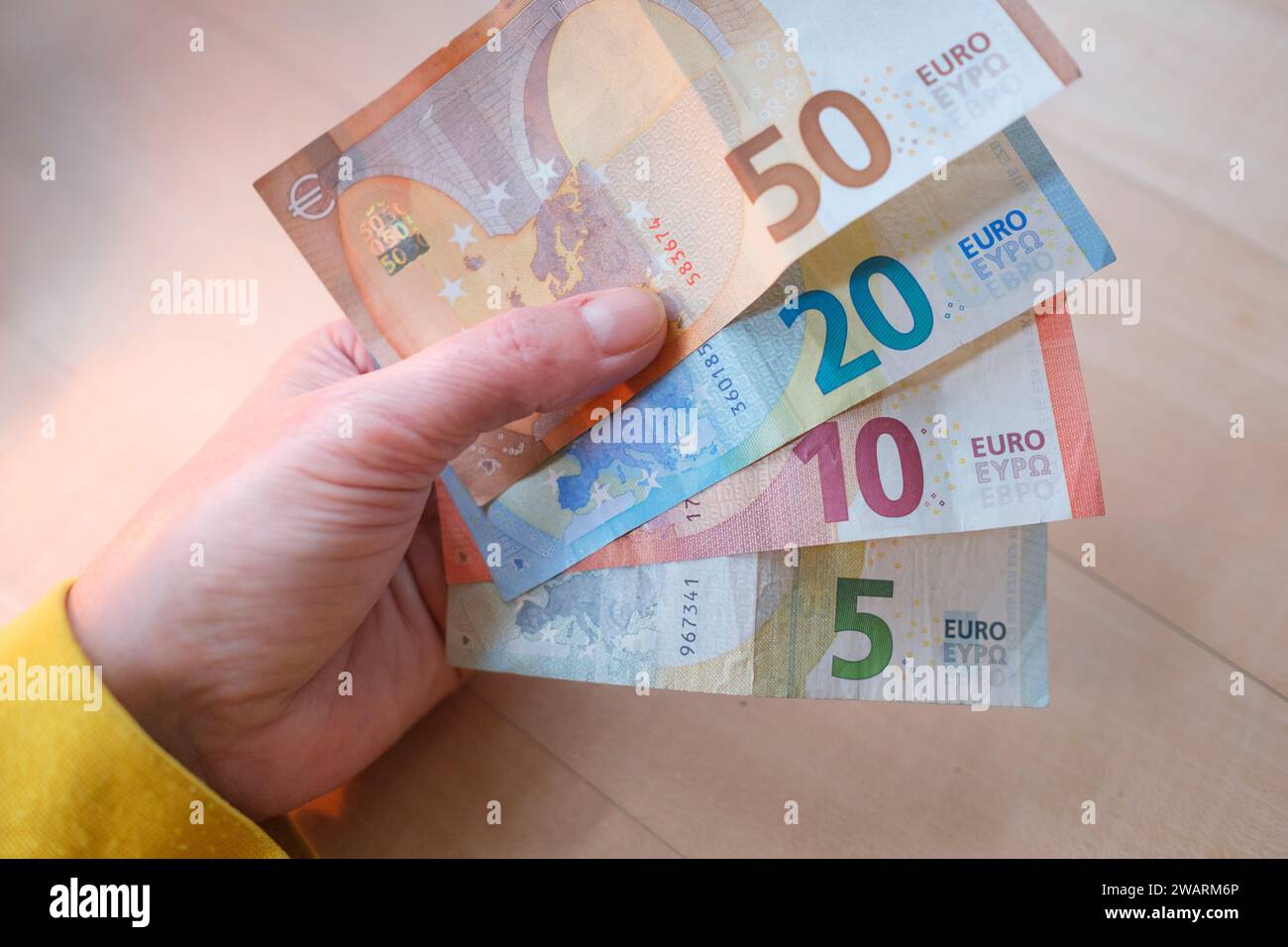 La mano di una donna in possesso di varie banconote in euro Foto Stock